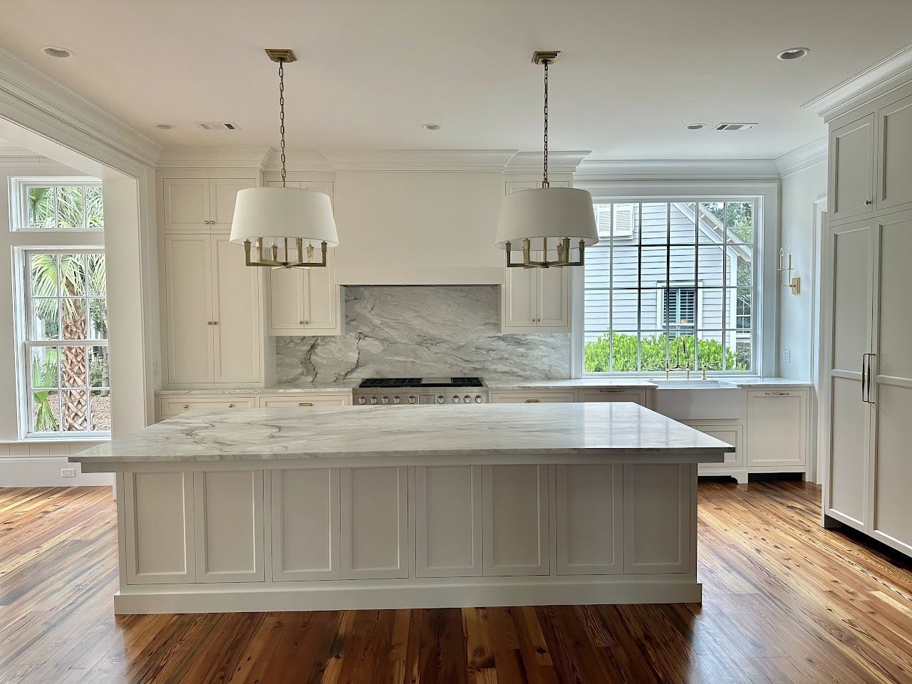 White kitchen with marble island and custom cabinetry, by SV Construction