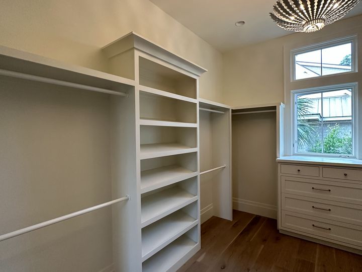 B walk in closet with shelving tower drawers and window, by SV Construction