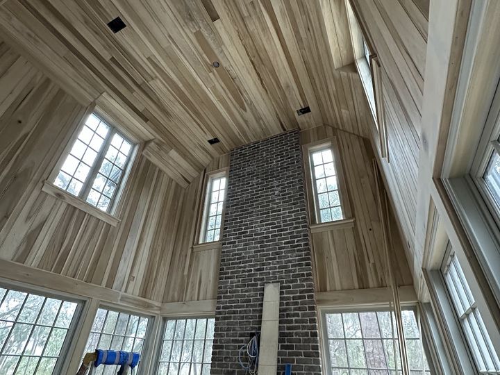 Vaulted wood paneled ceiling and walls around a brick chimney, by SV Construction