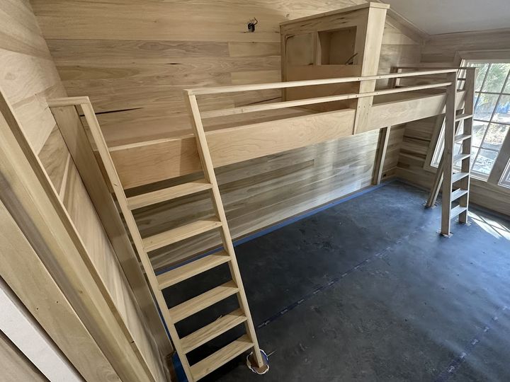 Wood paneled loft with two ladders, by SV Construction