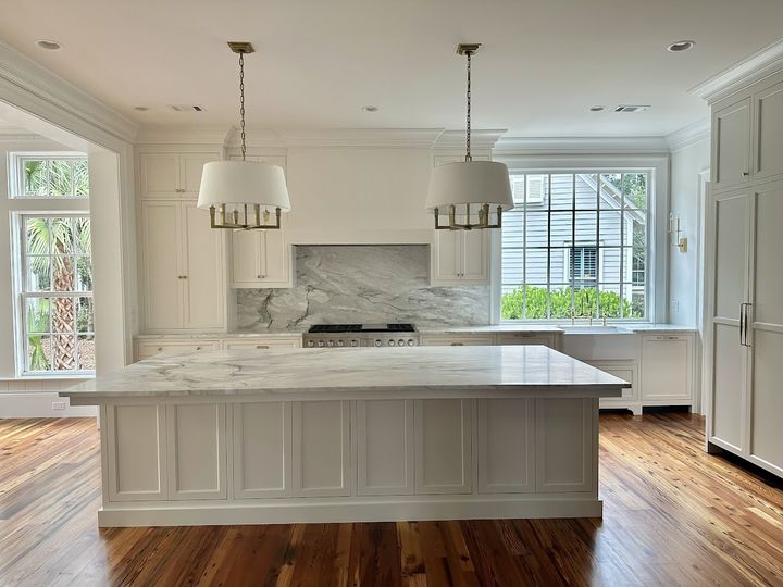 White kitchen with marble island and custom cabinetry, by SV Construction