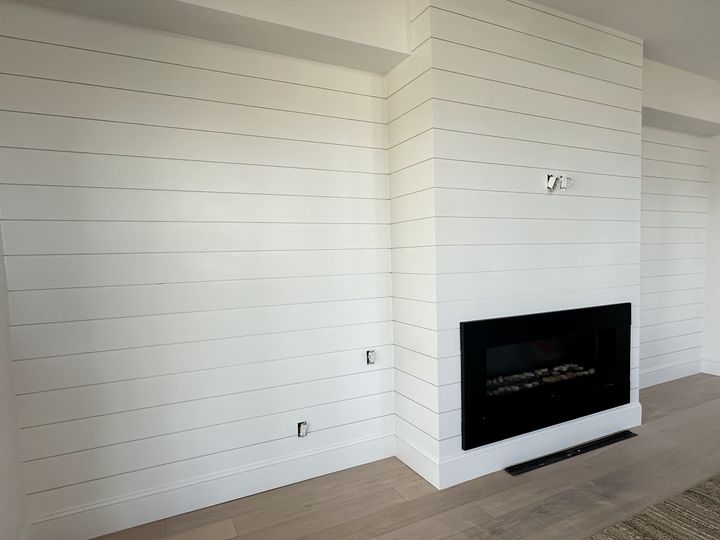 White shiplap wall with built in fireplace, by SV Construction