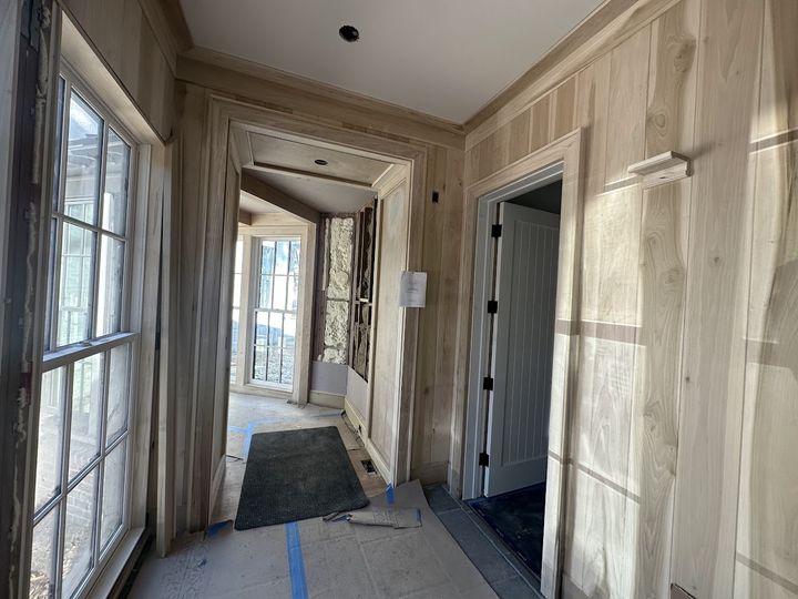 Wood paneled hallway with cased openings and crown molding, by SV Construction